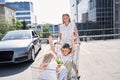 Jolly young female carrying cart with children Royalty Free Stock Photo