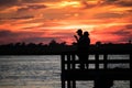 Jones Beach, New York - July 20, 2018 : Silhouettes of men fishing at the Jones Beach fishing piers right after a beautiful sunset Royalty Free Stock Photo