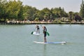 kids on a stand paddle on the pond of the leisure center of Jonzac