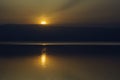 Jordan. Dead Sea. Calm at sea. Sunset on Dead Sea coast. Orange sun is reflected in water. There is light path in water