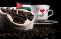 Jordanian flag in a bag with coffee beans isolated on black