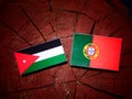 Jordanian flag with Portuguese flag on a tree stump isolated