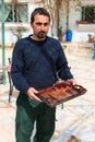 Jordanian man offering tea to the tourists visiting a local house