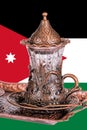 Jordanian tea set. Teacup with traditional arabic ornaments on the background of the Jordanian flag Royalty Free Stock Photo