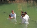 JORDANITE, ISRAEL. Ablution of a boy in the holy waters of the Jordan River
