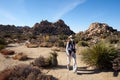 JOSHUA TREE NATIONAL PARK, CALIFORNIA, USA Ã¢â¬â DECEMBER 22, 2020: Woman with masks walking the trail in HIdden Valley of Joshua Royalty Free Stock Photo