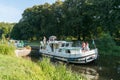 Houseboats with tourists pass through river locks on the river Oust near Josselin in Brittany