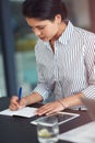 Jotting down her ideas. a young businesswoman writing notes at an office desk. Royalty Free Stock Photo