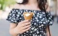 Joung woman holds vanilla ice cream in cone. .Vanilla ice cream in a waffle cone. Royalty Free Stock Photo