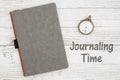 Journaling time with blank gray journal with pocket watch on a weathered whitewash wood background