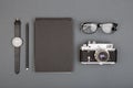 Journalist or blogger table - spiral blank notebook, pencil, camera and glasses on gray background, top view Royalty Free Stock Photo