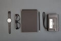 Journalist or blogger table - spiral blank notebook, pencil, tape recorder and glasses on gray background, top view Royalty Free Stock Photo