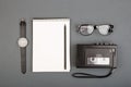 Journalist or blogger table - spiral blank notebook, pencil, tape recorder and glasses on gray background, top view Royalty Free Stock Photo