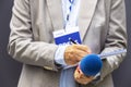 Journalist correspondent or reporter with press pass at media event, holding microphone, writing notes. Journalism concept Royalty Free Stock Photo