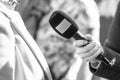 Journalist holding microphone making media or vox populi interview Royalty Free Stock Photo