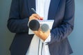 Journalist at media event or news conference, holding microphone, writing notes. Broadcast journalism concept. Royalty Free Stock Photo