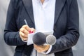 Journalist at news conference or media event, writing notes, holding microphone. Broadcast journalism concept.