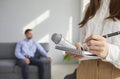 Journalist or TV correspondent with notepad, pen and mic in hands gets ready for interview