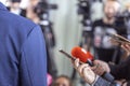 Journalists at news conference holding microphone and smartphone making media interview with unrecognizable politician or business Royalty Free Stock Photo