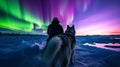 Journey Beneath the Aurora: Solo Traveler and Sled Dogs in the Arctic Royalty Free Stock Photo