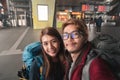 Journey vacations concept, Asian man and woman traveler with backpack standing take photo selfie in high speed train station Royalty Free Stock Photo