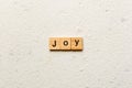 Joy word written on wood block. Joy text on cement table for your desing, concept