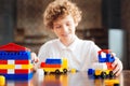 Cheerful curly haired kid playing at home