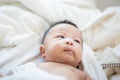 Joyful adorable infant baby boy lying on white blanket Royalty Free Stock Photo