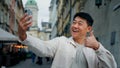 Joyful adult male tourist holding smartphone looking at screen taking pictures on webcam happy man blogger posing for Royalty Free Stock Photo