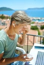 Joyful adult man wearing headphones sitting at outdoor cafe during Mediterranean vacation Royalty Free Stock Photo