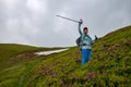 Joyful adventurer female with open arms on mountain meadow Royalty Free Stock Photo