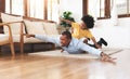 Joyful African American Father and little son playing aeroplane on floor together at home. Happy Smiling kid boy flying on Dad