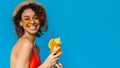 Joyful african american girl in swimwear holding summer cocktail and smiling at camera Royalty Free Stock Photo