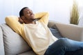 Joyful african american guy reclining on sofa at home Royalty Free Stock Photo