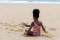 Joyful African American kid playing with sand at tropical beach Royalty Free Stock Photo