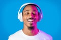 Joyful african american man listening to music, using wireless headphones Royalty Free Stock Photo