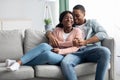 Joyful african american couple hugging and laughing, home interior Royalty Free Stock Photo