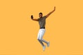 Joyful african americna man jumping over yellow background and showing smartphone with black screen to camera. Royalty Free Stock Photo