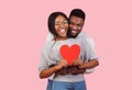 Joyful african couple holding big red heart together Royalty Free Stock Photo