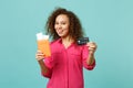 Joyful african girl in casual clothes holding passport boarding pass ticket credit bank card isolated on blue turquoise Royalty Free Stock Photo