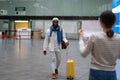 Happy african man employee with luggage going to female waiting for him with sign board in airport Royalty Free Stock Photo