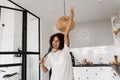 Joyful African young woman having fun with kitchen utensils. African american housewife in apron singing with spatulas Royalty Free Stock Photo