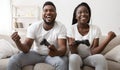 Joyful afro couple celebrating victory in video game Royalty Free Stock Photo