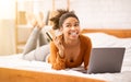 Joyful Afro Girl Doing Online Shopping Lying In Bed Indoor Royalty Free Stock Photo