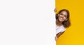 Joyful afro girl looking from big white board for advertising Royalty Free Stock Photo