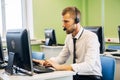 Joyful agent working in a call center with his headset Royalty Free Stock Photo