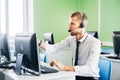 Joyful agent working in a call center with his headset Royalty Free Stock Photo