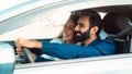 Joyful arab couple driving their new car and exploring roads, sitting with opened window Royalty Free Stock Photo