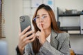 Joyful Asian businesswoman is having a video call on the phone, making hush sign or quiet gesture Royalty Free Stock Photo