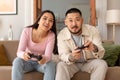 Joyful Asian Couple Playing Video Game Holding Joysticks At Home Royalty Free Stock Photo